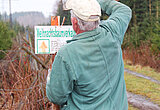 Linkziel: Link zum Beitrag mit dem Thema ThüringenForst bereitet das Weihnachtsbaumgeschäft vor ; Bildinhalt: Ein älterer Mann stellt ein Schild mit der Aufschrift "Weihnachtsbaumverkauf" auf